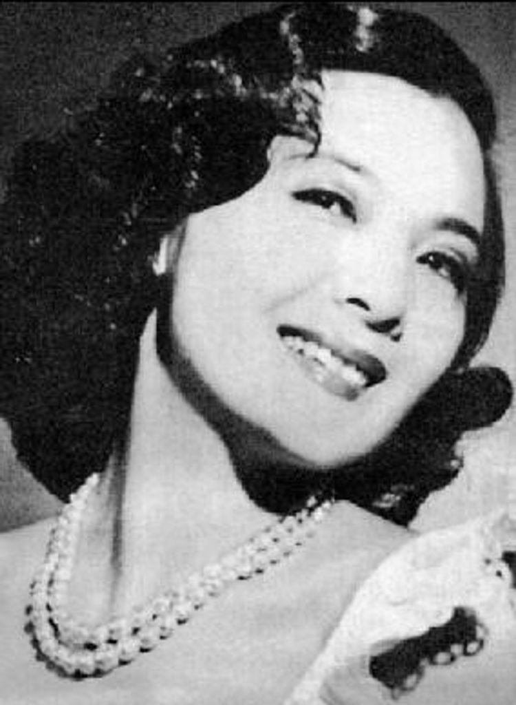 Yin Mingzhu, black and white, undated picture. She has short, wavy hair. She is also wearing a lipstick and a pearl necklace.