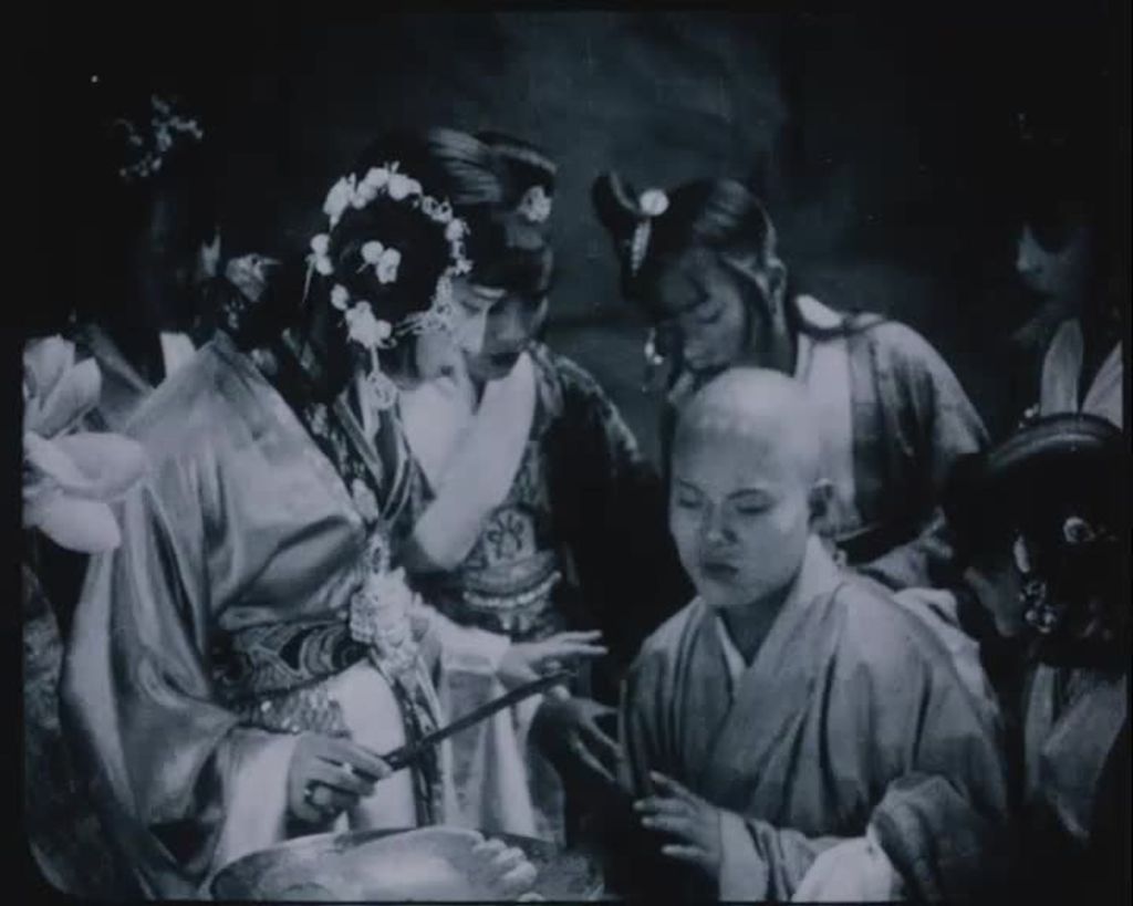 Some people are wearing traditional Chinese clothes. Some women are around a bald man.