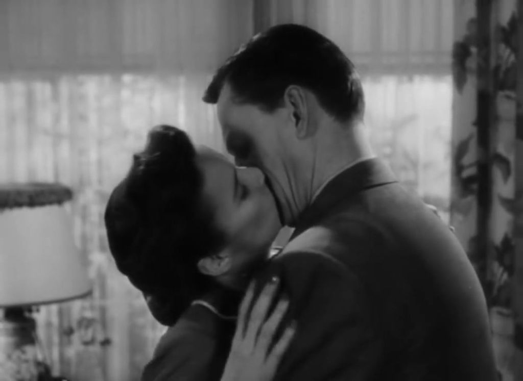 A man and a woman embrace and kiss.